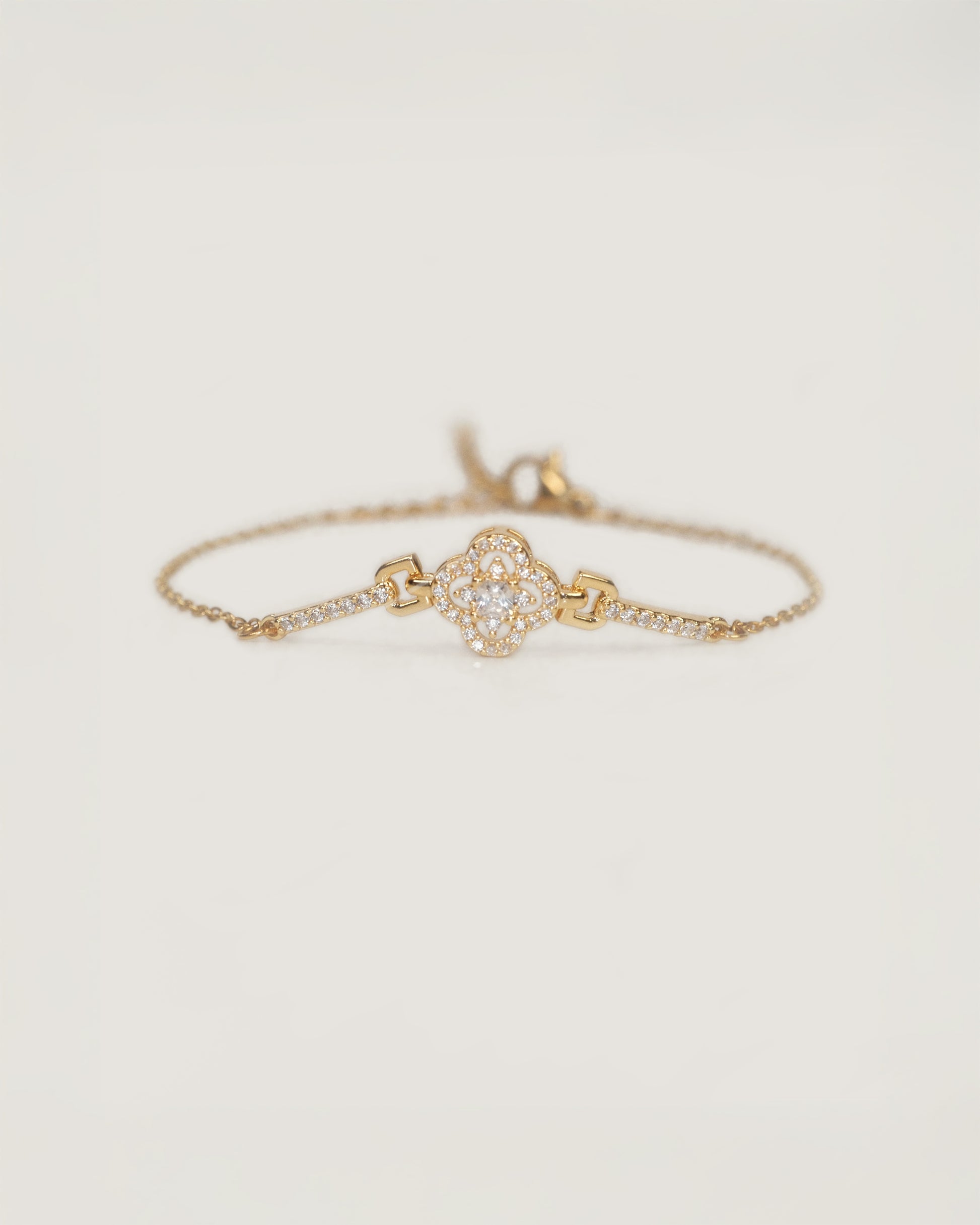 Pulsera acero inoxidable bañado en oro diseño cuatro pétalos ornamentado con zirconias y detalles pavé